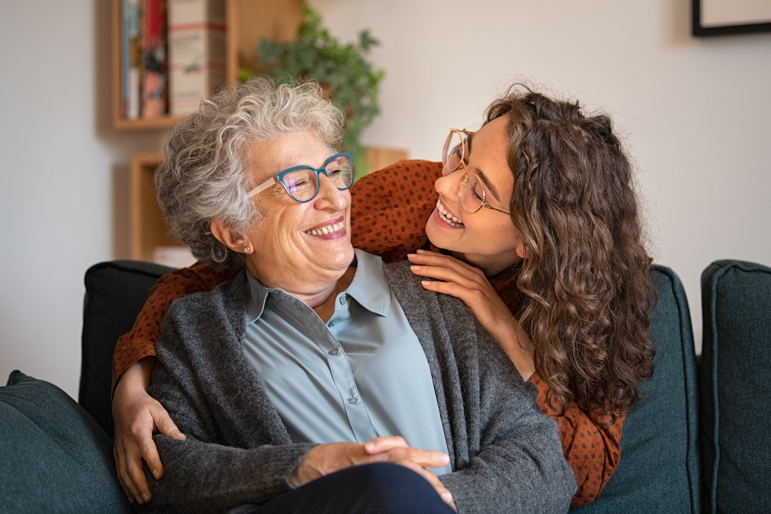 Happy grandmother with smiling granddaughter at home