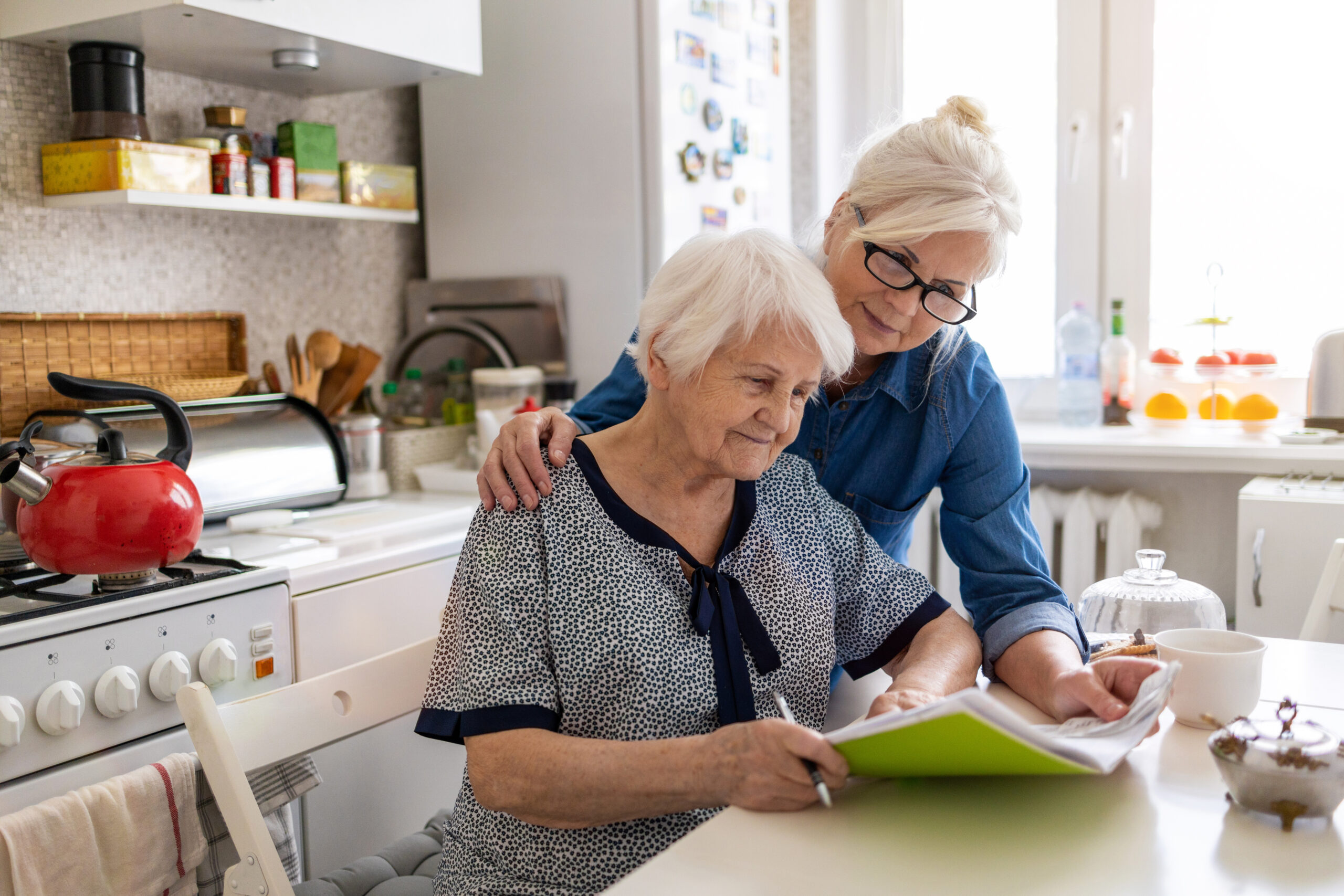 AdobeStock_356679797 Two women looking through notebook and papers together