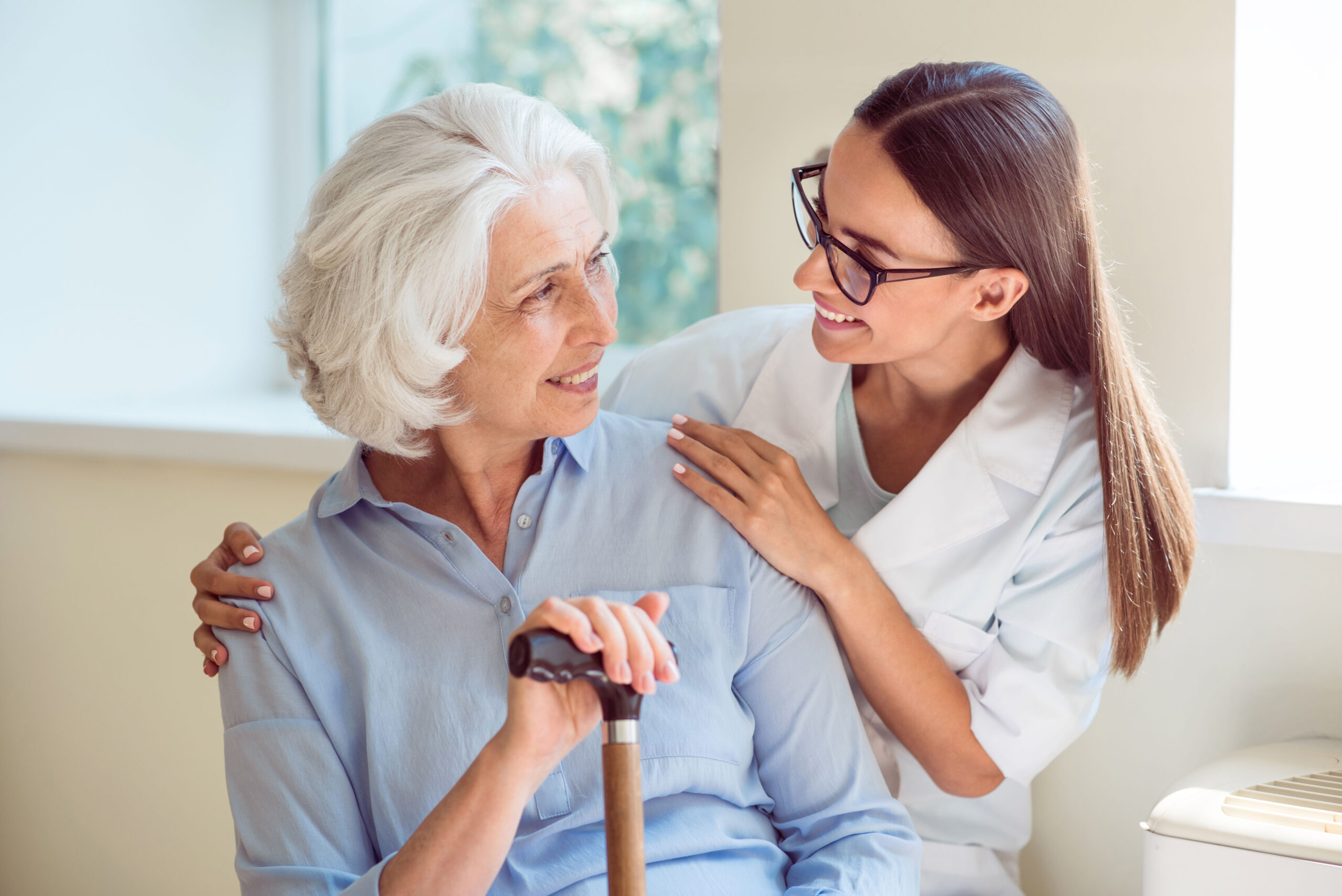 Happy woman sitting on bench with caregiver