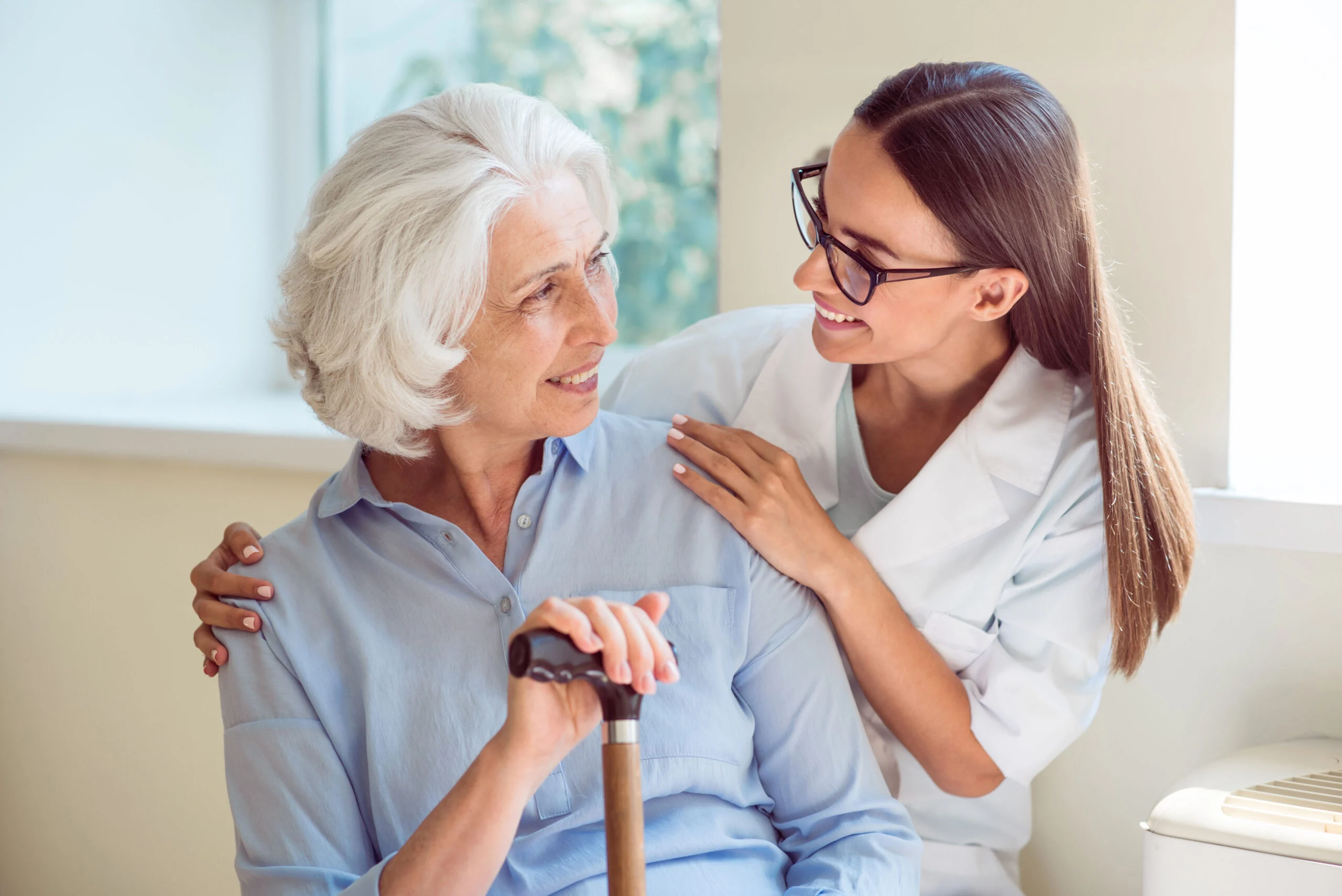 Happy woman sitting on bench with caregiver