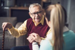 Elderly man speaking to caregiver
