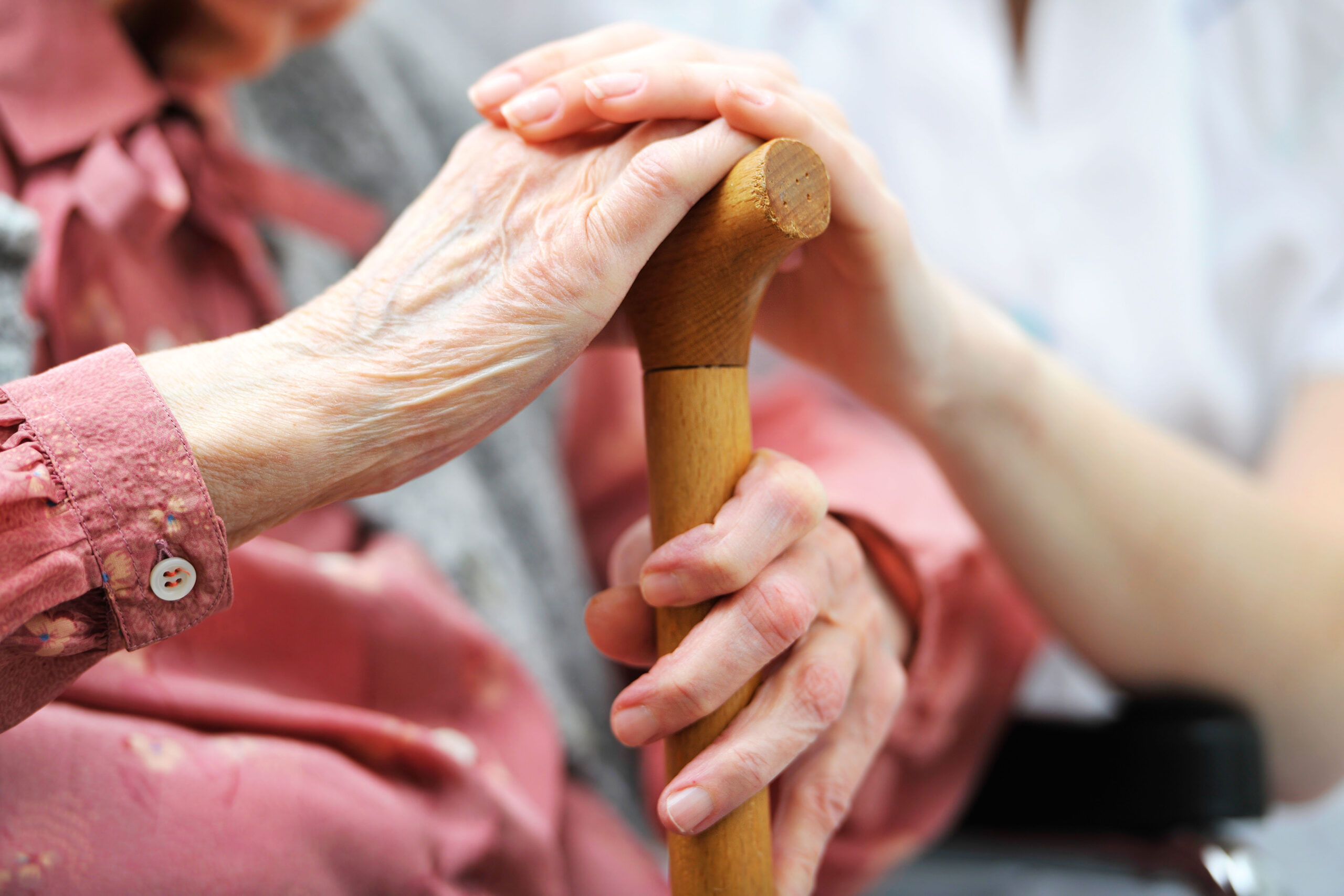 Closeup of hands over cane